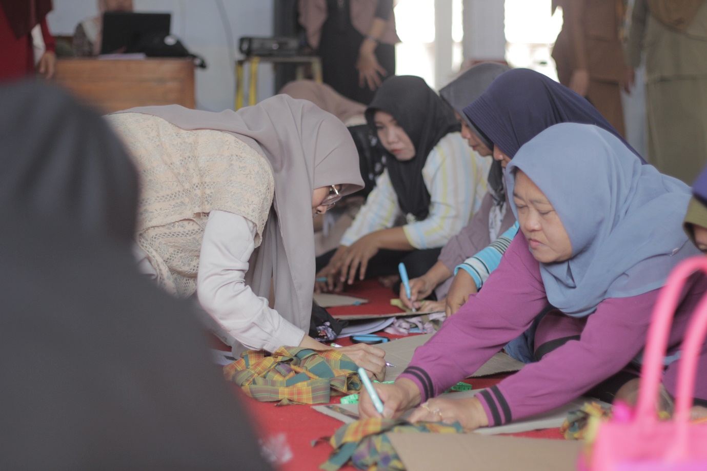 A group of women working on a project

Description automatically generated
